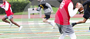 Quarterback about to pass to receiver in a 7 on 7 football game with a blurred background