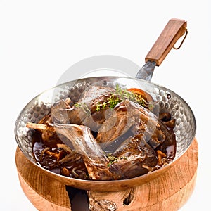 Quartered wild rabbit served in a copper pan
