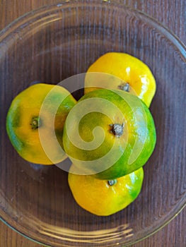 Quartet of green and yellow oranges on a plate