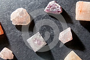 Quartz crystal pyramid and gem stones on slate