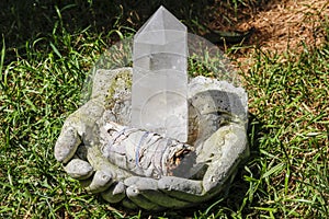 Quartz crystal and sage in hands