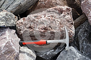 Geological Hammer with raw quartz stone in the natural background. Pointed-Tip Rock Picks photo