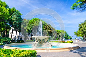 Quattro cavalli Four horses fountain with turquoise water in Parco Federico Fellini park with green trees in Rimini photo