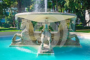 Quattro cavalli Four horses fountain with turquoise water in Parco Federico Fellini park with green trees in touristic city centre