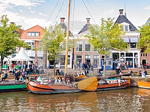 People and historic boats in old harbour during event Admiralty Days, Dokkum, Friesland, Netherlands