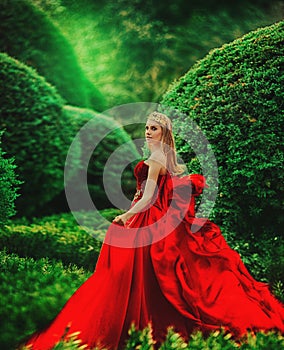 the queen in a red dress walks in the garden