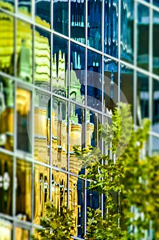 Queen Victoria Building reflected in modern glass high rise building, toy camera effect, Sydney city center, Australia.