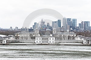 Queens House, Old Royal Naval College and Canary Wharf from Greenwich Park in winter snow