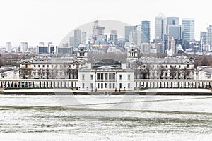 Queens House, Old Royal Naval College and Canary Wharf from Greenwich Park in winter snow