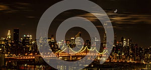 Queensboro Bridge seen at night with the moon overhead