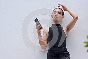 Queer LGBT community supporter man with mustache against white background using mobile phone photo