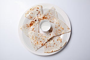 Quesadilla with beef and chicken on a white plate. quesadilla and sauce.