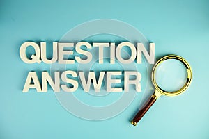 Question and Answer alphabet letters with magnifying glass on blue background