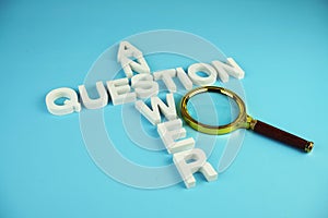 Question and Answer alphabet letters with magnifying glass on blue background