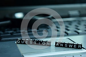 Question Answer text wooden blocks in laptop background. Business and technology concept photo
