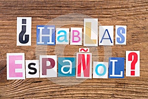 Question `Hablas Espanol?` on wooden background