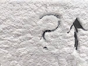 A question mark and arrow written in the snow. The cold frosty texture of the snow and the question mark. Background