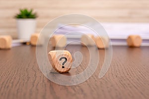 question mark cube stand on wooden background with copy space.