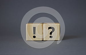 Question mark and exclamation mark symbol. Question mark and exclamation mark on wooden cubes. Beautiful grey background. Business