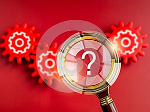 Question mark icon symbol on magnifying glass appear while looking through red gears on red background.