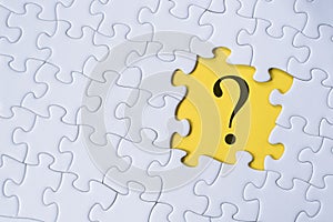 Question mark on jigsaw puzzle with yellow background