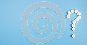 Question mark made from medical pills on a blue background. Treatment theme concept. Banner. Copy space