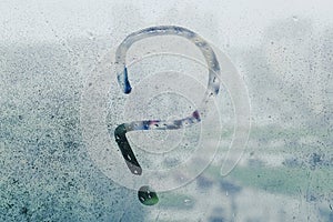 A question mark painted on wet glass