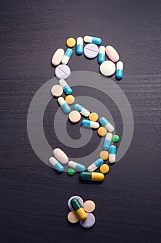 Question mark.Punctuation.Pharmacy background on a black table. Tablets on a black background. Pills.Medicine and healthy