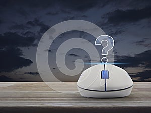 Question mark sign icon with wireless computer mouse on wooden table over sunset sky, Business customer support concept