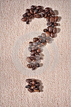 Question-mark symbol made from coffee crops on beige background
