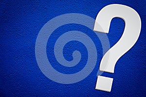 Question mark symbol in minimalist white grey color 3D isolated on simple dark blue background diagonally with empty copy space photo
