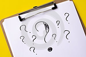 A question mark on a white sheet . FAQ frequency asked questions, Answer and Brainstorming Concepts