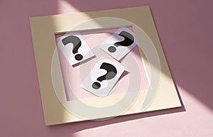 A question mark on a white sheet in the frame . FAQ frequency asked questions, Answer, Information and Brainstorming Concepts