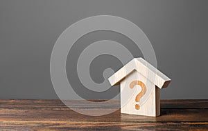 Question mark on a wooden house. Cost estimate. Solving housing problems, deciding to buy or rent real estate. Search for options