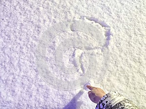 A question mark written in the snow and hand. The cold frosty texture of the snow and the question mark. Background