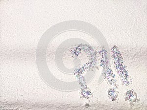 A question mark written on snow with sequins or confetti. The concept of Uncertainty of choice, expectations, and