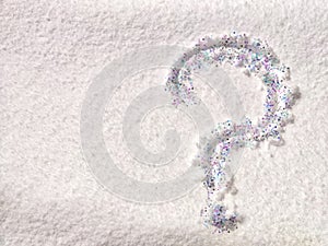 A question mark written on snow with sequins or confetti. The concept of Uncertainty of choice, expectations, and