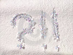 A question mark written on snow with sequins or confetti. The concept of Uncertainty of choice, expectations, and