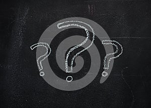 Question marks on black chalkboard