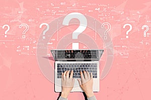 Question marks with person using laptop