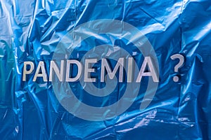 The question pandemia translation from spanish - pandemic laid with silver letters on crumpled blue plastic film photo
