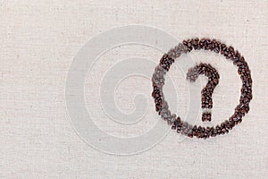 Question symbol in circle from coffee beans on linen texture, aligned middle right