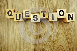 Question word in wooden cube alphabet letters on wooden background