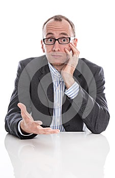 Questioningly bald engineer or specialist sitting at desk isolated on white.