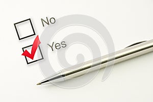 Questionnaire: yes no choice, marked check box with a pen on paper background. Approval concept