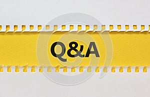 Questions and answers symbol. White and yellow paper. Words `Q and A, Questions and answers`. Beautiful yellow background.