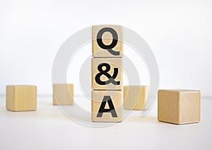 Questions and answers symbol. Word `Q and A, questions and answers` on wooden cubes on a beautiful white background. Business,