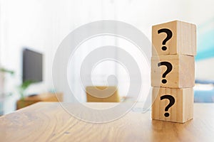 Questions Mark with wooden cube blocks on interior table background