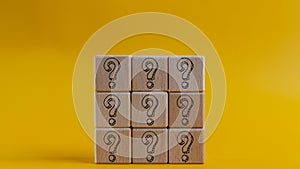 Questions Mark words with a wooden cube block on a yellow background. FAQ( frequency asked questions), Answer, Q and A,