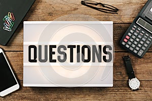 Questions word in vintage style light box on office deskt op